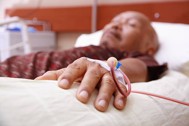 Blood transfusion on a hand of an old man Process of a blood transfusion to an old asian person. Focus on his hand and blur on his face, while he's lying on hospital bed. dialysis photos stock pictures, royalty-free photos & images