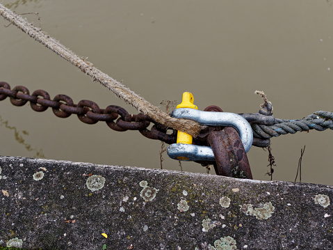 Various fastening methods, rope, chain, of ships to a metal ring on the bank wall.