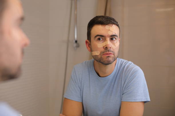istock Man with band aids all over his face 1872214429