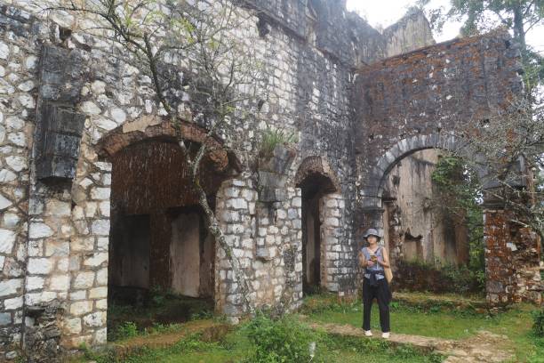 un turista cinese si trova fuori dalle rovine della vecchia chiesa francese vicino al villaggio di ta phin nel vietnam settentrionale - vietnam vietnamese culture vietnamese ethnicity north vietnam foto e immagini stock