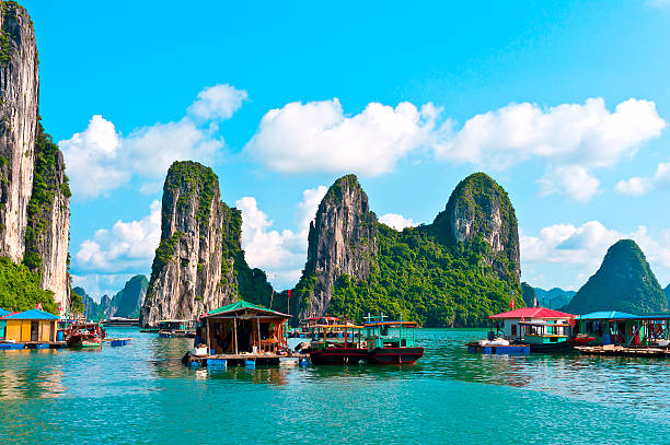 Floating village with rock islands Floating village and rock islands in Halong Bay, Vietnam, Southeast Asia gulf of tonkin photos stock pictures, royalty-free photos & images