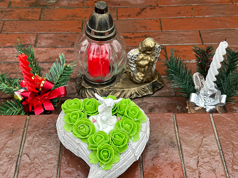 Lantern and angel figurine on a grave in the public cemetery