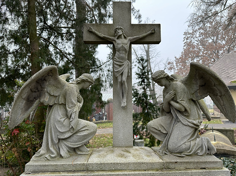 Jesus Christ and two angel statue on a tombstone in the public cemetery