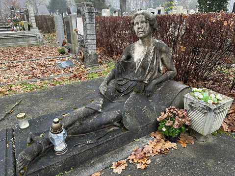 Old statue on a grave in the public cemetery