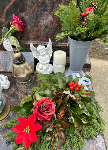 Wreath and lantern on a tombstone in the public cemetery