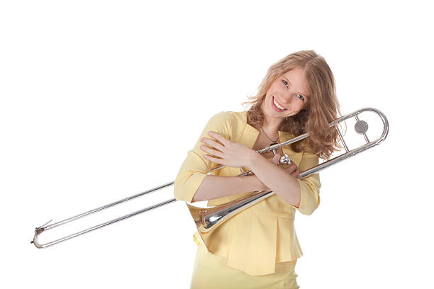 istock young woman in yellow holding trombone 187226543