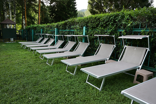 Row of sunloungers near the swimming pool, lounge chairs