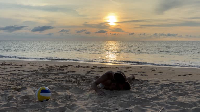 Father and son playing on the beach at the sunset time