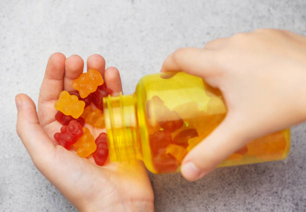 istock A girl holds a gummy bear vitamines in her hands 1872274929