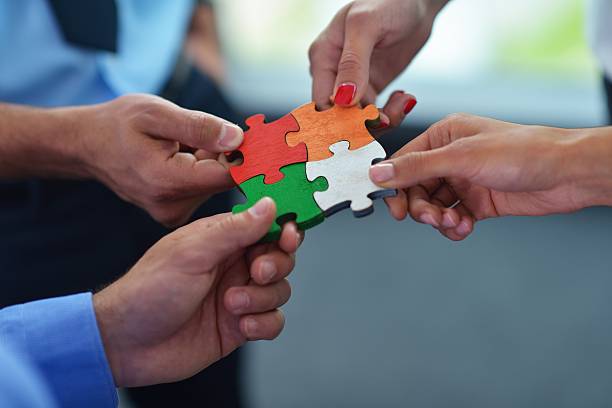 istock Group of business people assembling jigsaw puzzle 187227639