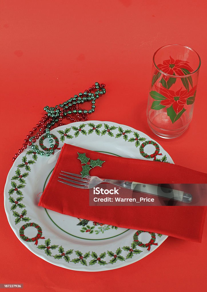 Christmas Dishes-Vertical Plate and glass in Christmas Motif with colorful beads against all red background. Bead Stock Photo