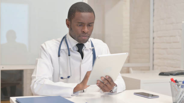 istock African Doctor Browsing Internet on Tablet in Hospital 1872283447