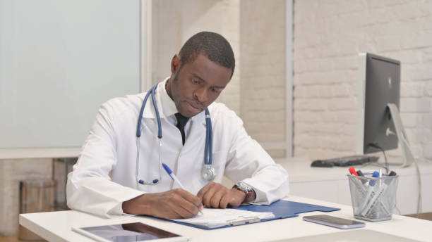 istock African Doctor Doing Paperwork in Hospital 1872285031