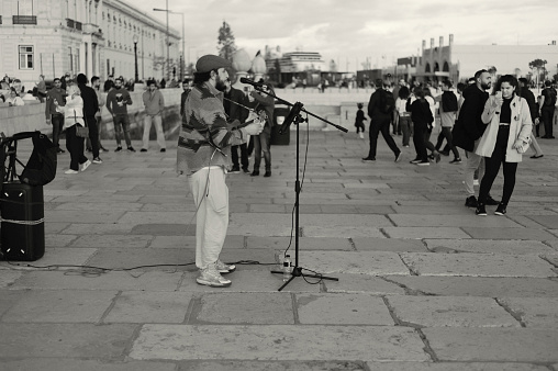 Lisbon, Portugal - November 11, 2023: A street musician plays a ukelele at the Praça do Comércio square in Lisbon downtown.