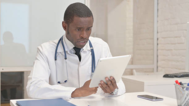 istock African Doctor Doing Video Chat on Tablet in Clinic 1872289880