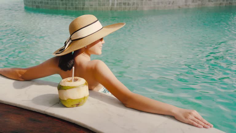 Woman relaxing in Swimming pool Sunbathe and admire the sea view