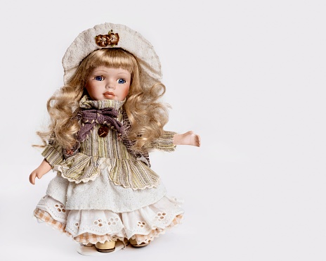 Head of old children's toy doll and hands against white background