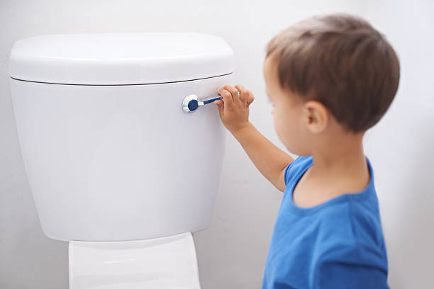 All done! Shot of a cute young boy flushing a toilet potty toilet child bathroom stock pictures, royalty-free photos & images