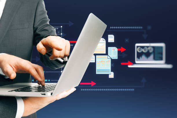 istock Close up of businessmen hands using laptop with creative big data transfer and digital transformation hologram on blue background. Teamwork concept. 1872298504