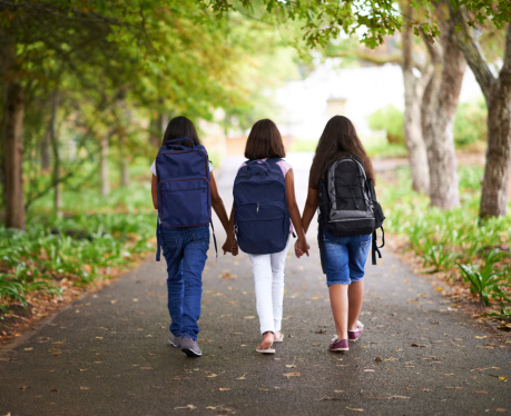 Three young female classmates walking outside