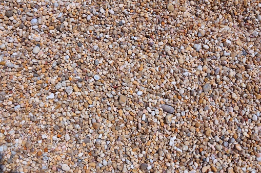 Pebbles background - shingle beach pattern in Gargano Peninsula, Italy.