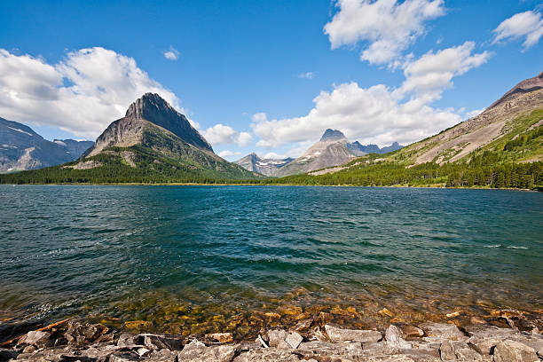 Grinnell Point from Swiftcurrent Lake The pyramid shaped Grinnell Point dominates the landscape in the Many Glacier area of Glacier National Park, Montana, USA. This picture was taken from the Many Glacier Lodge on Swiftcurrent Lake. jeff goulden glacier national park stock pictures, royalty-free photos & images