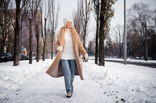 Photo of charming lovely woman going path in park walking snowy park in town cold weather outside.