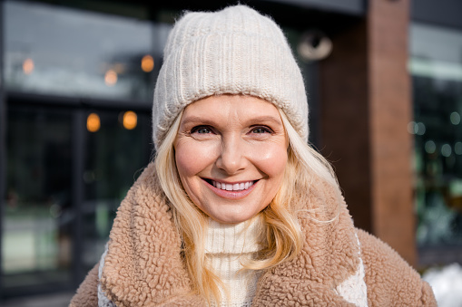 Photo of pretty cheerful woman wear beige coat smiling walking winter day outside urban city street.