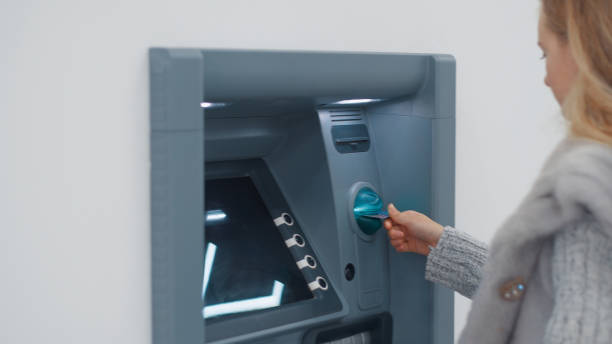 istock Girl inserts card into ATM 1872350961