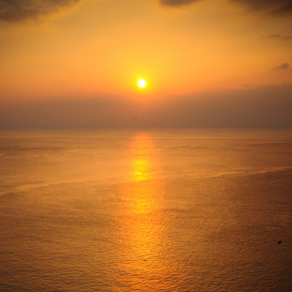 beautiful silhouette sunset at tropical sea with a bit natural lens flair .