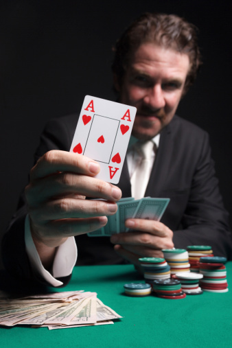 Gambler holding ace of hearts card.
