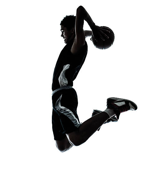 basketball player dunking silhouette one young man basketball player dunking silhouette in studio isolated on white background silhouette of basketball player slam dunk stock pictures, royalty-free photos & images