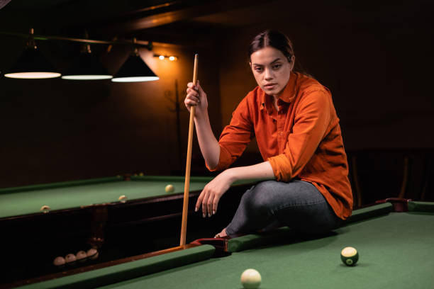 istock Young Caucasian woman playing pool on a green table 1872372240