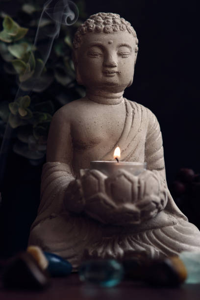 istock stone statue of buddha with a candle 1872382294