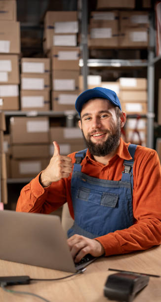 istock Warehouse worker smiling and thumbs up while working with inventory in warehouses, supply chain and logistic network 1872386482