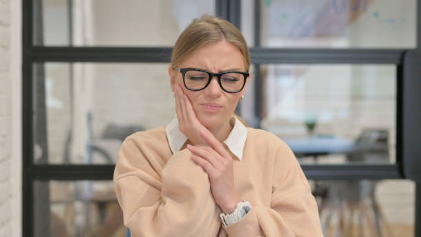 istock Uncomfortable Young Woman with Toothache in Office 1872398511