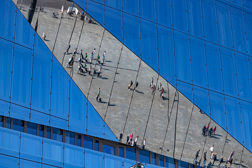 Berlin, Germany - September 24, 2023: A picture of the people and on the Washingtonplatz being reflected on the glass of the 3XN Cube Berlin building.
