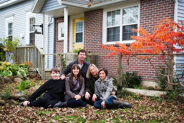carino paio di bambini e adolescenti con bella casa in autunno - mahone bay foto e immagini stock