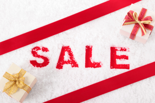 Sale sign written in snow with gift boxes