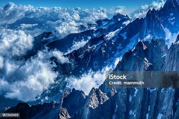 Foto de Picos De Montanha Cercado Por Nuvens e mais fotos de stock de Acima - Acima, Alpes europeus, Cordilheira