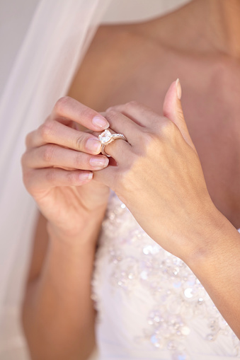 Beautiful bride in her wedding dress touching her wedding ring