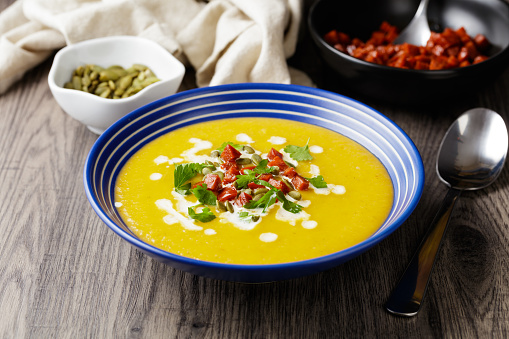 close view of dicilous butternut squash soup with fried diced chorizo sausage and fine chopped parsley