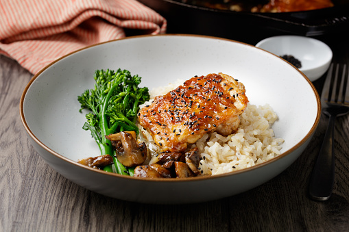 Stir fry with chicken, red paprika, mushrooms and chives in frying pan. Asian cuisine dish. Gray kitchen table background, top view, copy space