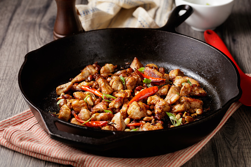 close view of  home made kung pao chicken in a cast iron skillet