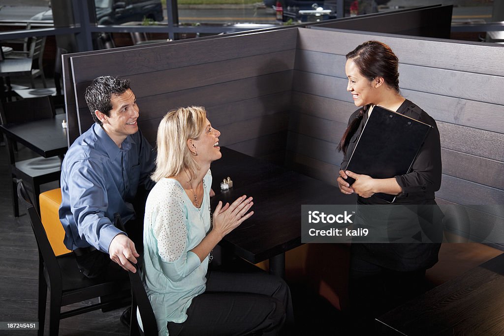 Латиноамериканцы официантка разговаривать с клиентами - Стоковые фото Обсуждение роялти-фри