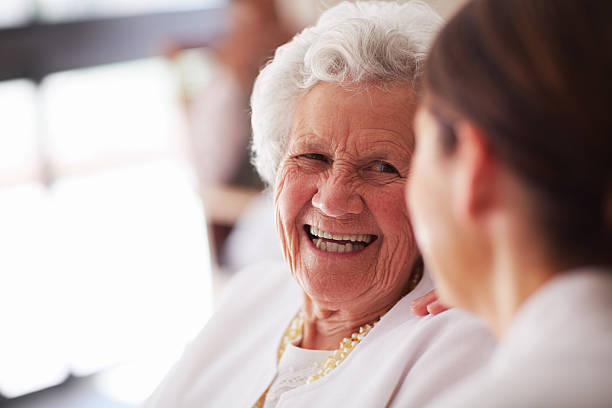 портрет улыбающегося пожилые женщина и медсестра - grandmother standing senior women senior adult стоковые фото и изображения