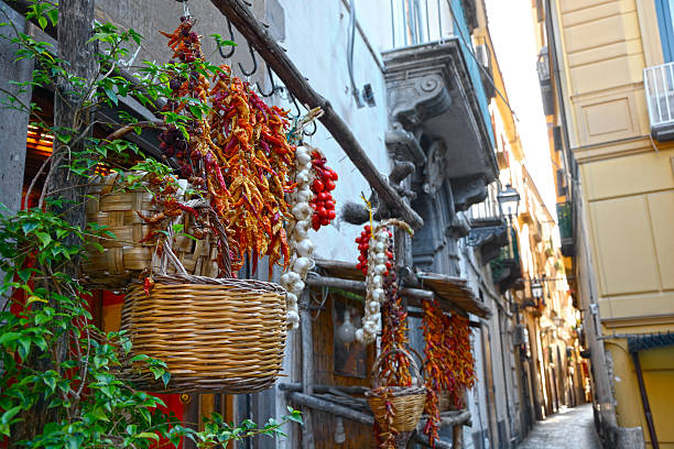 Baskets and plants hanging up outside on an Italian street Narrow street in Sorrento, with traditional grocery in the foreground sorrento italy photos stock pictures, royalty-free photos & images