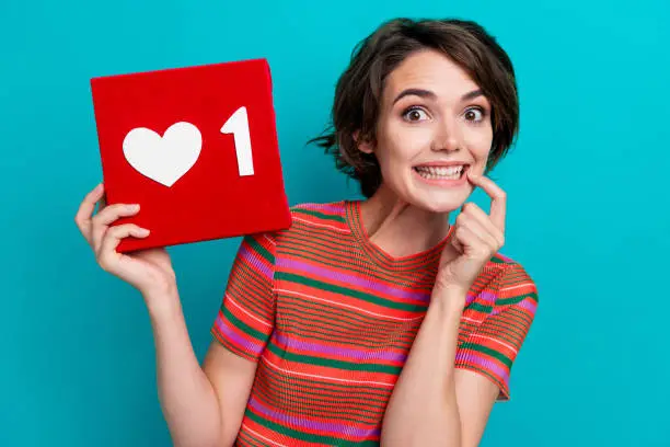 Photo of Portrait of impressed girl blogger with short hairstyle wear stylish shirt hold like box finger on teeth isolated on teal color background