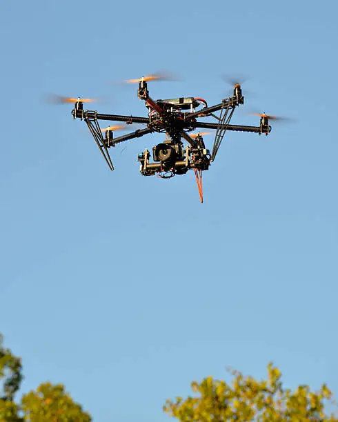 Small camera mounted on a remote-control helicopter in flight.