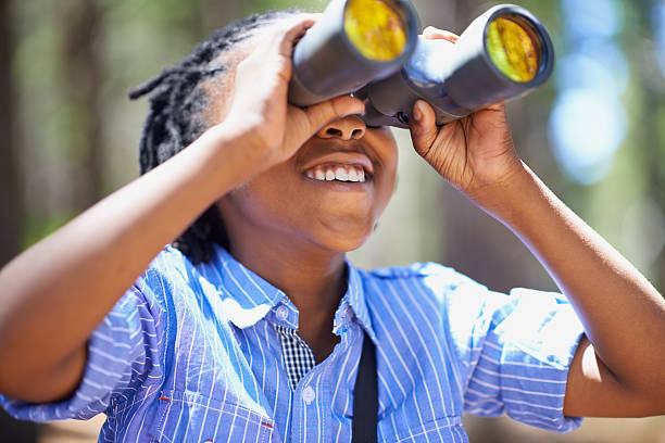 He loves bird watching! Shot of a young boy out in the woods with a pair of binoculars bird watching stock pictures, royalty-free photos & images